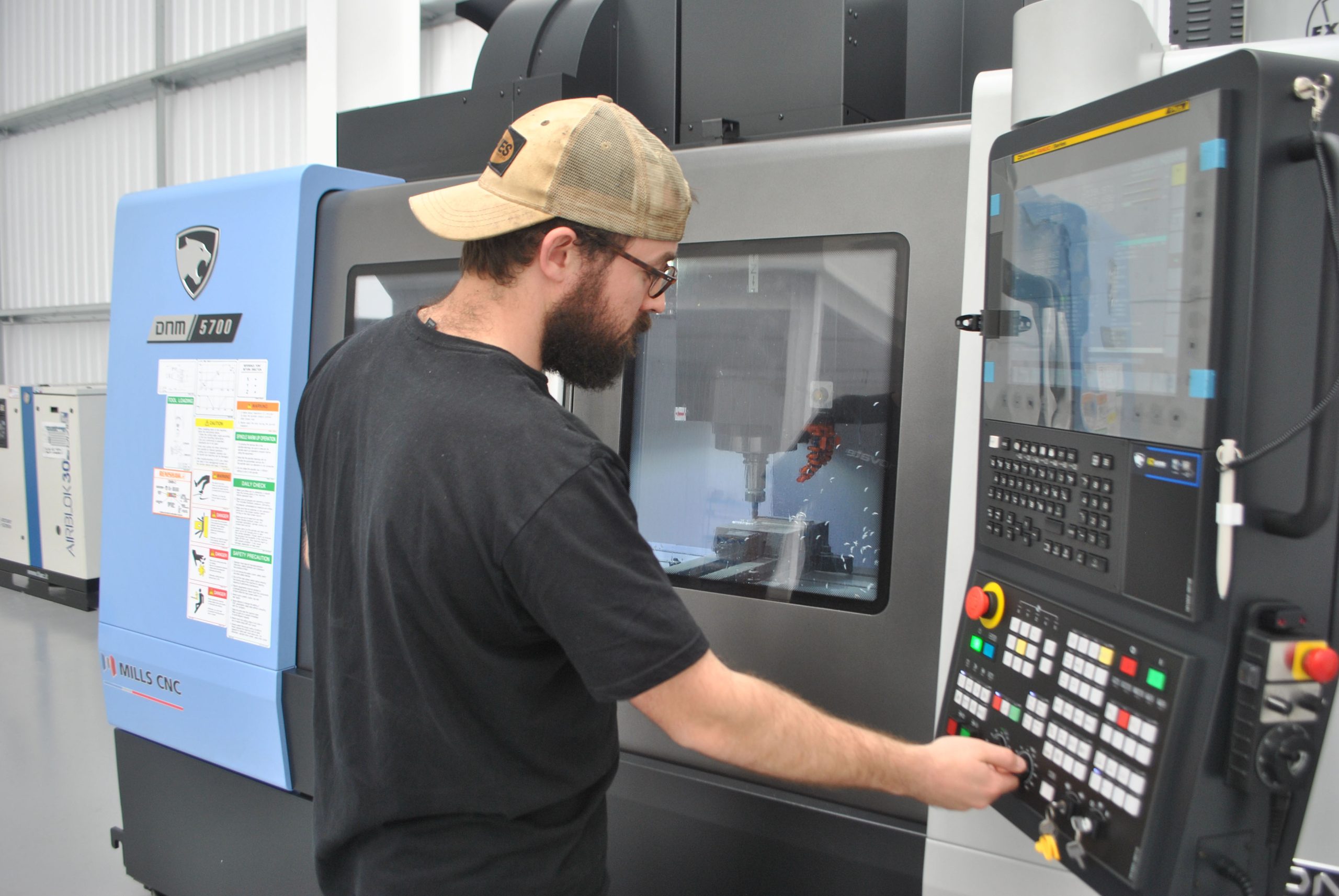 Operator manning a DN Solutions DNM 5700 machining centre