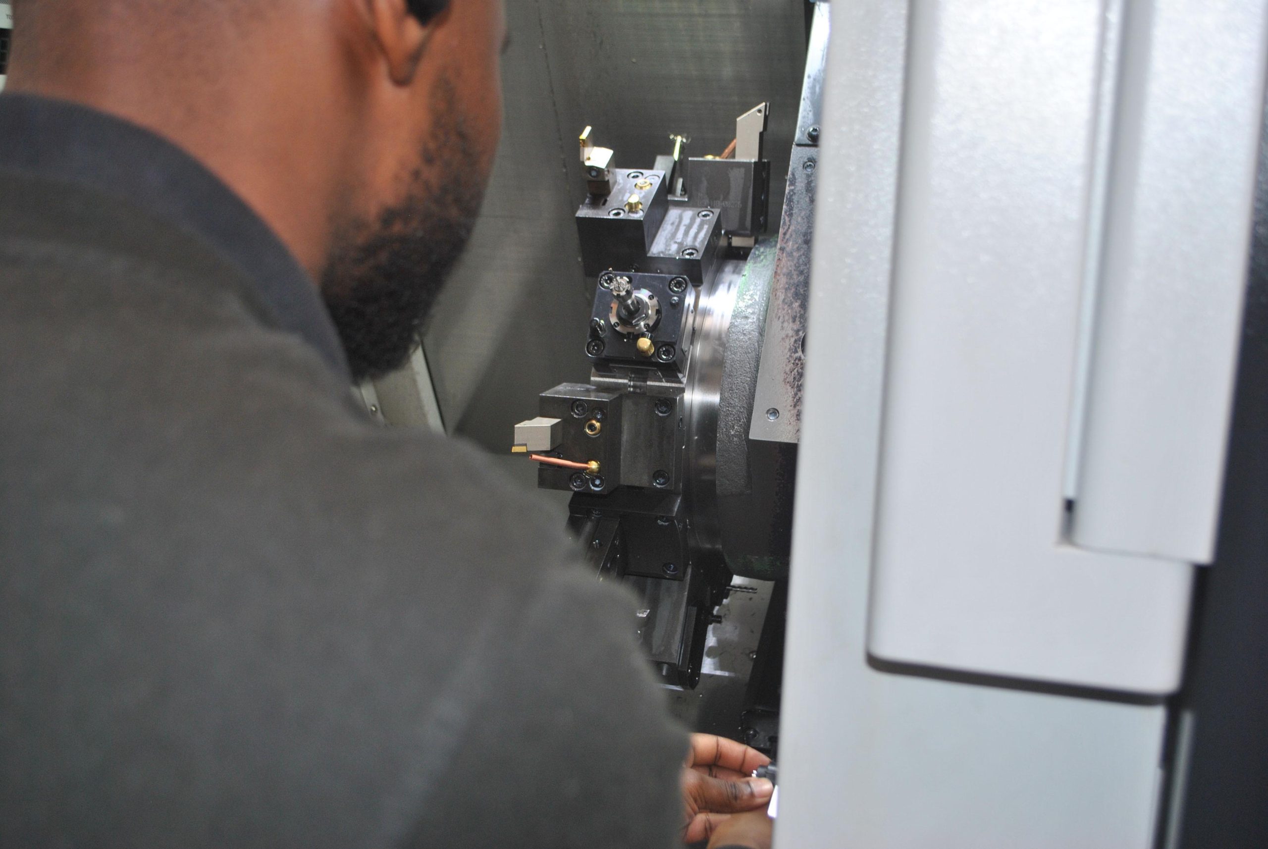 Looking over the shoulder of an Operator into the interior of a Doosan Lynx 2100LSYA Horizontal Single Turret Lathe