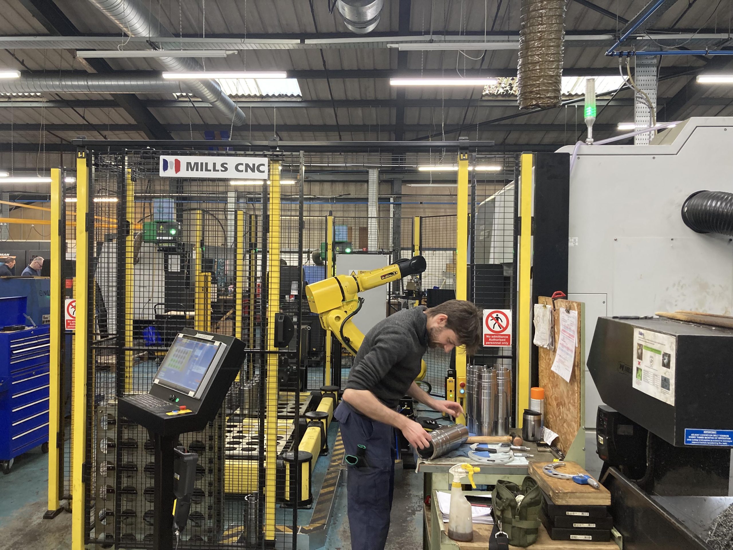 Operator working alongside an Automated Manufacturing Cell for Puma TT2500SY Twin Turret Horizontal Lathe