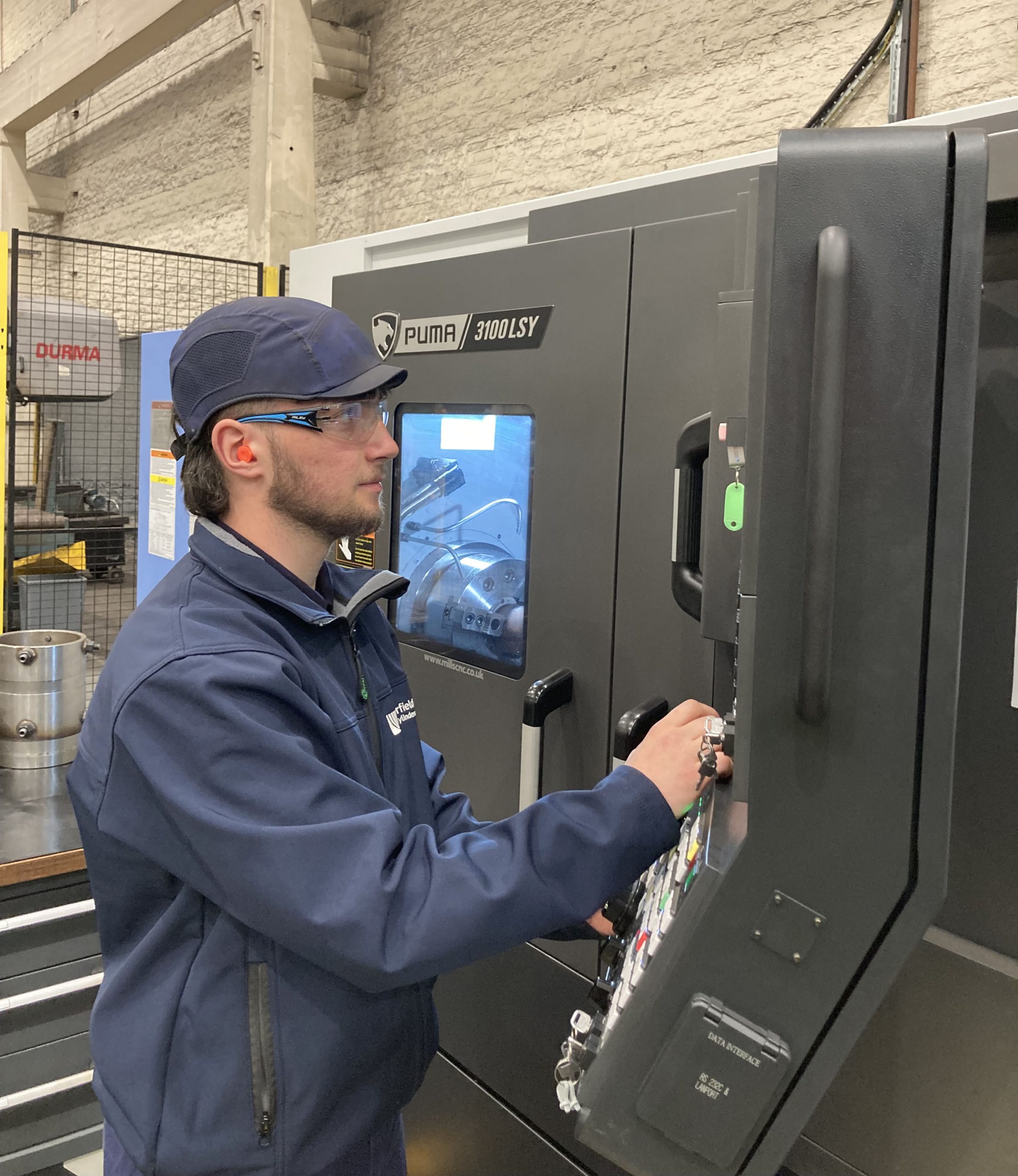 An operator at a DN Solutions Puma 3100LSY Horizontal Single Turret Lathe